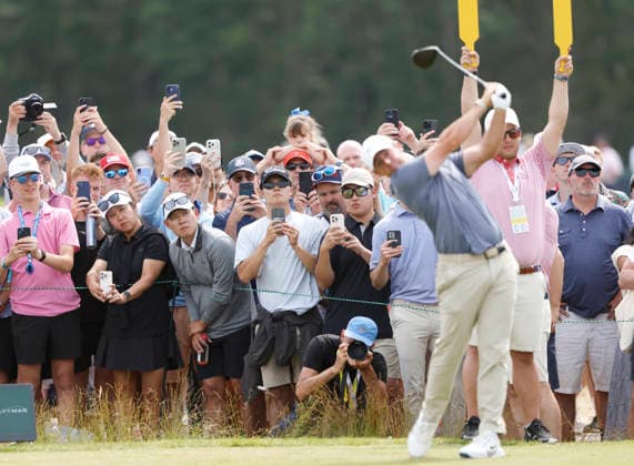 Spectators watch as Rory McIlroy of Northern Ireland hits a tee shot on the 5th hole in the second round of the 126th U.S. Open Golf Championship at Shinnecock Hills Golf Club in Southampton, NY on Friday, June 19, 2026.  NYC202606191016 JOHNxANGELILLO