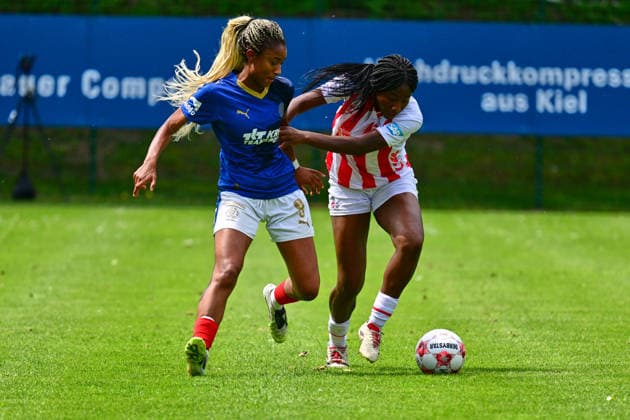 20.06.2026, Fußball, Frauen, Regionalliga, Relagation zur 2. Bundesliga, Saison 2025 2026, Holstein Kiel - 1. FC Köln, Holstein Women Toyosi Mary Doherty am Ball gegen Kiels Janine Minta Kiel, Holstein-Stadion Waldwiese, VfB Kiel Platz Schleswig-Holstein Deutschland *** June 20, 2026, Soccer, Womens, Regional League, Promotion Relegation to the 2. Bundesliga, 2025–2026 Season, Holstein Kiel 1 FC Köln, Holstein Women’s Toyosi Mary Doherty in action against Kiel’s Janine Minta, Kiel, Holstein Waldwiese Stadium, VfB Kiel Field, Schleswig-Holstein, Germany,detected_source_language