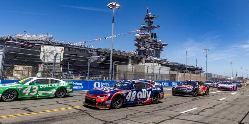 SAN DIEGO, CA - JUNE 21: Erik Jones of the 43 LEGACY MOTOR CLUB Dollar Tree Toyota, Alex Bowman of the 48 Hendrick Motorsports Ally Chevrolet, and Connor Zilisch of the 88 Trackhouse Racing Red Bull Chevrolet among the field rounding turn 3 past the USS Carl Vinson (CVN70), during the Anduril 250 NASCAR, Motorsport, USA Cup Series Race, Sunday, June 21, 2026, at Naval Base Coronado in San Diego, California. (Photo by Tony Ding Icon Sportswire) AUTO: JUN 21 NASCAR Cup Series Anduril 250 Race the Base EDITORIAL USE ONLY Icon46520260621001250