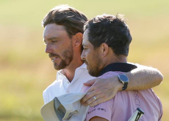 Xander Schauffele and Tommy Fleetwood of England hug after finishing the 18th hole during the final round of the 126th U.S. Open Golf Championship at Shinnecock Hills Golf Club in Southampton, NY, on Sunday, June 21, 2026.  NYC20260621869 JOHNxANGELILLO