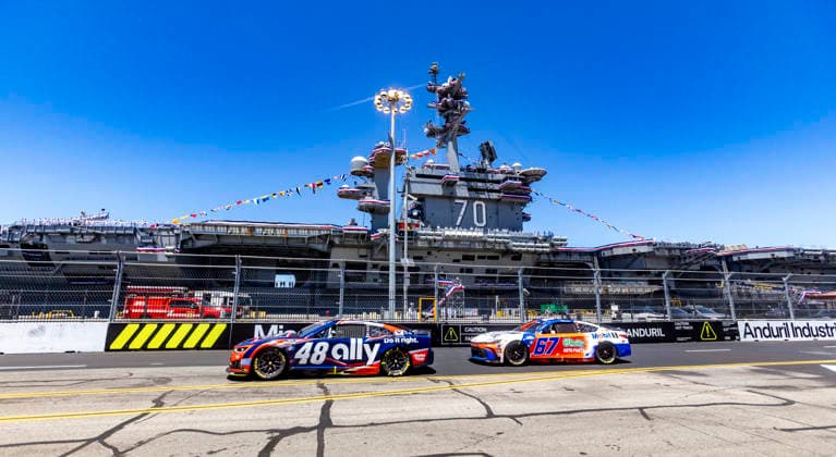 SAN DIEGO, CA - JUNE 21: Alex Bowman of the 48 Hendrick Motorsports Ally Chevrolet and Corey Heim of the 67 23XI Open MOBIL 1 O REILLY AUTO PARTS Toyota pass by the USS Carl Vinson (CVN70) at turn 2 during the Anduril 250 NASCAR, Motorsport, USA Cup Series Race, Sunday, June 21, 2026, at Naval Base Coronado in San Diego, California. (Photo by Tony Ding Icon Sportswire) AUTO: JUN 21 NASCAR Cup Series Anduril 250 Race the Base EDITORIAL USE ONLY Icon46520260621025250
