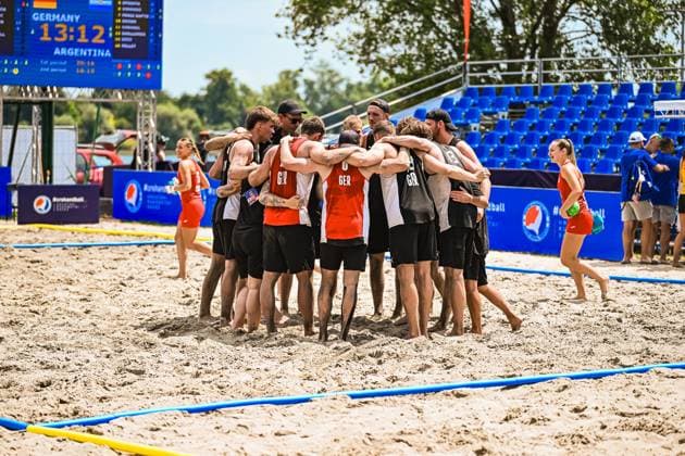 Die deutsche Beachhandball-Nationalmannschaft bildet nach dem 13:12-Sieg gegen Argentinien einen Jubel-Kreis auf dem Sandplatz am Jarun See in Zagreb. Die Anzeigetafel im Hintergrund zeigt das Endergebnis Germany 13:12 Argentina. IHF Beach Handball World Championship, WM, Weltmeisterschaft 2026, 23.06.2026, Zagreb, Jarun See *** After their 13–12 victory over Argentina, the German national beach handball team forms a celebratory circle on the sand court at Lake Jarun in Zagreb. The scoreboard in the background shows the final score Copyright: xspeedshotx xDorianfrickx