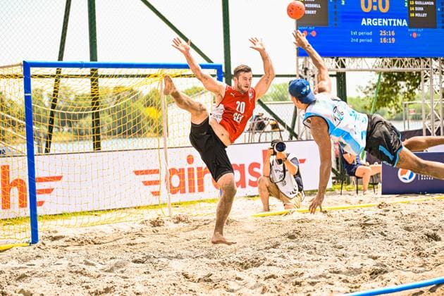 Oliver Middell ( 20; Deutschland Beachhandball Nationalmannschaft) streckt sich als Torwart im Tor aus, um einen Wurf des argentinischen Angreifers abzuwehren. Im Hintergrund ist die Anzeigetafel mit dem Spielstand und dem Gegner Argentinien am Jarun See in Zagreb sichtbar. IHF Beach Handball World Championship, WM, Weltmeisterschaft 2026, 23.06.2026, Zagreb, Jarun See *** Oliver Middell, No. 20 on the German national beach handball team, stretches out in goal to block a shot by the Argentine attacker. In the background, the scoreboard showing the score and the opponent, Argentina, is visible at Lake Jarun in Zagreb. IHF Beach Handball World Championship 2026, June 23, 2026, Zagreb, Lake Jarun,detected_source_language Copyright: xspeedshotx xDorianfrickx
