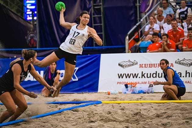 Lena Klingler ( 17; Deutsche Frauen Beachhandball Nationalmannschaft) springt hoch und zieht zum Wurf ab, während zwei Gegenspielerinnen in schwarzen Trikots versuchen, den Abschluss zu blocken. Die Szene findet am Jarun See in Zagreb vor gut besetzten Zuschauerrängen statt. IHF Beach Handball World Championship, WM, Weltmeisterschaft 2026, 23.06.2026, Zagreb, Jarun See *** Lena Klingler, a member of the German women’s beach handball national team, jumps high and takes a shot, while two opponents in black jerseys try to block the shot. The scene takes place at Lake Jarun in Zagreb in front of a large crowd. 2026 IHF Beach Handball World Championship, June 23, 2026, Zagreb, Lake Jarun,detected_source_language Copyright: xspeedshotx xDorianfrickx