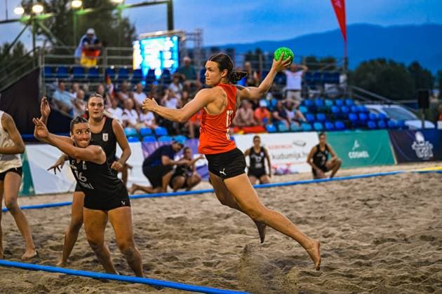 Eine Spielerin der USA springt im Abwurf über den Sand, während zwei Spielerinnen der Deutschen Frauen Beachhandball Nationalmannschaft die Aktion zu blocken versuchen. Das Spiel findet am Jarun See in Zagreb vor gefüllten Tribünen statt. IHF Beach Handball World Championship, WM, Weltmeisterschaft 2026, 23.06.2026, Zagreb, Jarun See *** A player from the U.S. jumps over the sand during a throw, while two players from the German women’s national beach handball team try to block the shot. The game is taking place at Lake Jarun in Zagreb in front of packed stands. IHF Beach Handball World Championship 2026, June 23, 2026, Zagreb, Lake Jarun,detected_source_language Copyright: xspeedshotx xDorianfrickx
