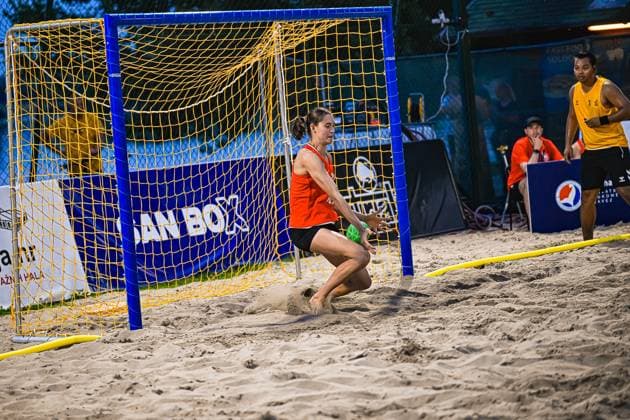 Eine Torhüterin im roten Trikot wirft sich im Sand in eine Parade und hält den grünen Ball vor dem Tor. Im Hintergrund beobachtet ein Spieler in gelbem Trikot die Szene. IHF Beach Handball World Championship, WM, Weltmeisterschaft 2026, 23.06.2026, Zagreb, Jarun See *** A goalkeeper in a red jersey dives into the sand to make a save and stops the green ball before it reaches the goal. In the background, a player in a yellow jersey watches the scene. 2026 IHF Beach Handball World Championship, June 23, 2026, Zagreb, Lake Jarun,detected_source_language Copyright: xspeedshotx xDorianfrickx