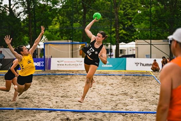 Lena Klingler ( 17; Deutsche Frauen Beachhandball Nationalmannschaft) springt hoch und zieht zum Wurf ab, während eine Gegenspielerin der USA woman den Abschluss zu blocken versucht. Die Szene findet am Jarun See in Zagreb auf Sandboden statt, der grüne Ball ist klar im Bild. IHF Beach Handball World Championship, WM, Weltmeisterschaft 2026, 23.06.2026, Zagreb, Jarun See *** Lena Klingler, a member of the German women’s national beach handball team, jumps high and takes a shot while an opponent from the U.S. women’s team tries to block the shot. The scene takes place on the sandy shore of Lake Jarun in Zagreb; the green ball is clearly visible in the picture. IHF Beach Handball World Championship 2026, June 23, 2026, Zagreb, Lake Jarun,detected_source_language Copyright: xspeedshotx xDorianfrickx