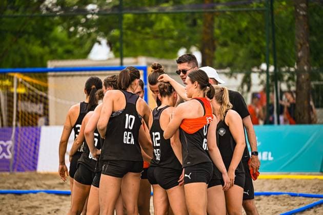 Die Deutsche Frauen Beachhandball Nationalmannschaft bildet eine Spielertraube auf dem Sandfeld am Jarun See in Zagreb. Isabel Kattner ( 10; GER) und Dilayla Alarslan ( 12; GER) sind von hinten erkennbar, ein Trainer gibt taktische Anweisungen. IHF Beach Handball World Championship, WM, Weltmeisterschaft 2026, 23.06.2026, Zagreb, Jarun See *** The German womens national beach handball team gathers on the sand court at Lake Jarun in Zagreb. Isabel Kattner (10 GER) and Dilayla Alarslan (12 GER) can be seen from behind, and a coach is giving tactical instructions. 2026 IHF Beach Handball World Championship, June 23, 2026, Zagreb, Lake Jarun,detected_source_language Copyright: xspeedshotx xDorianfrickx