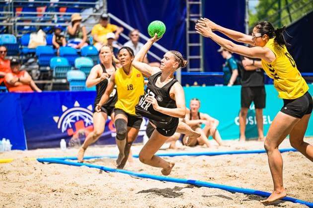 Eine Spielerin der Deutschen Frauen Beachhandball Nationalmannschaft zieht im Sand zum Wurf hoch, während eine Gegenspielerin in Gelb den Abschluss zu blocken versucht. Im Hintergrund läuft eine weitere Gegenspielerin ( 18) heran. IHF Beach Handball World Championship, WM, Weltmeisterschaft 2026, 23.06.2026, Zagreb, Jarun See *** A player on the German womens national beach handball team winds up for a shot on the sand, while an opponent in yellow tries to block the shot. In the background, another opponent, No. 18, is running toward her. 2026 IHF Beach Handball World Championship, June 23, 2026, Zagreb, Lake Jarun,detected_source_language Copyright: xspeedshotx xDorianfrickx
