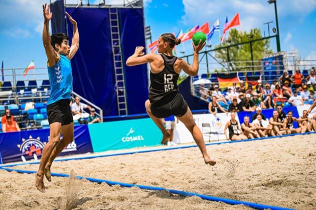 Dilayla Alarslan ( 12; Deutsche Frauen Beachhandball Nationalmannschaft) springt mit dem Ball zum Wurf ab, während ein Gegenspieler im blauen Trikot den Abschluss zu blocken versucht. Die Szene findet auf dem Sandplatz am Jarun See in Zagreb vor gut besetzten Tribünen statt. IHF Beach Handball World Championship, WM, Weltmeisterschaft 2026, 23.06.2026, Zagreb, Jarun See *** Dilayla Alarslan, a member of the German women’s beach handball national team, jumps with the ball to take a shot, while an opponent in a blue jersey tries to block the shot. The scene takes place on the sand court at Lake Jarun in Zagreb in front of a well-attended crowd. 2026 IHF Beach Handball World Championship, June 23, 2026, Zagreb, Lake Jarun,detected_source_language Copyright: xspeedshotx xDorianfrickx