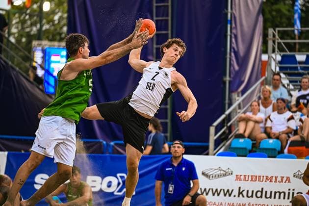 Lennart Wörmann ( 2; Deutschland Beachhandball Nationalmannschaft) springt dynamisch zum Wurf und wird von einem Gegenspieler im grünen Trikot geblockt. Sand fliegt auf, während beide Spieler am Jarun See in Zagreb um den Ball kämpfen. IHF Beach Handball World Championship, WM, Weltmeisterschaft 2026, 23.06.2026, Zagreb, Jarun See *** Lennart Wörmann 2, a member of the German national beach handball team, leaps dynamically to take a shot and is blocked by an opponent in a green jersey. Sand flies up as both players battle for the ball at Lake Jarun in Zagreb. 2026 IHF Beach Handball World Championship, June 23, 2026, Zagreb, Lake Jarun,detected_source_language Copyright: xspeedshotx xDorianfrickx