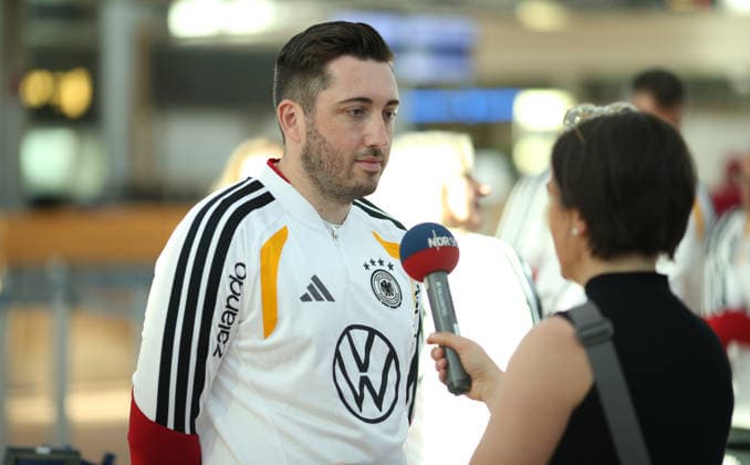 Abreise der deutschen Walking-Football-Nationalmannschaft zur UEFA Walking Football EURO Cup 2026, der ersten offiziellen Europameisterschaft in der Fußball-Variante in Nyon. Der Hamburger Fußball-Verband (HFV) stellte das DFB-Team für die Veranstaltung vom 24. bis 26. Juni. Die Abreise erfolgte am Mittwochmorgen vom Hamburg Airport Helmut Schmidt in Richtung Frankfurt. Von dort aus ging es dann nach Nyon. Im Bild: Teammanager Jean Künzel beim Interview mit dem Hörfunksender NDR 90,3. Fuhlsbüttel Hamburg *** Departure of the German Walking Football National Team for the 2026 UEFA Walking Football EURO Cup, the first official European Championship in this variation of soccer, in Nyon. The Hamburg Soccer Association (HFV) selected the DFB team for the event, which will take place from June 24 to 26. The team departed on Wednesday morning from Hamburg’s Helmut Schmidt Airport, heading for Frankfurt. From there, they traveled on to Nyon. Pictured