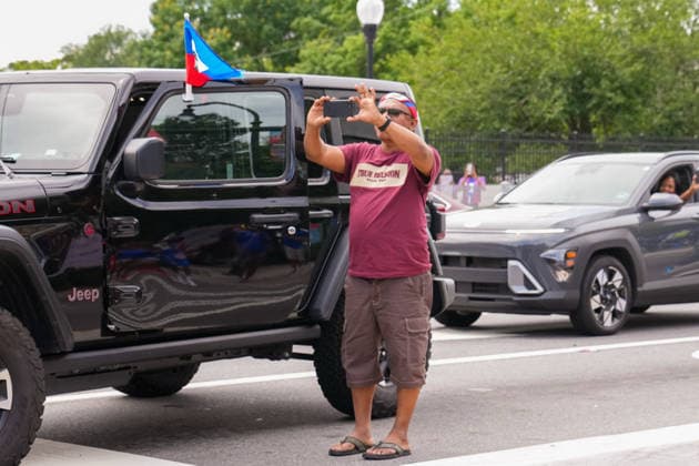 June 24, 2026, Atlanta, Georgia, United States of America: A man stands out his car recording the Haiti fan march during the Haiti fan march before the Morocco vs Haiti First Stage Group C match in ATLANTA, Georgia. Atlanta United States of America - ZUMAg276 20260624_zsp_g276_012 Copyright: xMalachixGabrielx