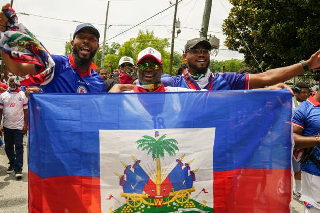 June 24, 2026, Atlanta, Georgia, United States of America: Three Haiti fans holding up the Haitian flag for the cameras during the Haiti fan march before the Morocco vs Haiti First Stage Group C match in ATLANTA, Georgia. Atlanta United States of America - ZUMAg276 20260624_zsp_g276_022 Copyright: xMalachixGabrielx