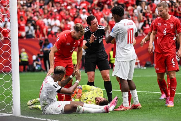 Match referee Ramon Abatti speaks with Jonathan David (captain) of Canada as Goalkeeper Gregor Kobel of Switzerland lays on the ground, Switzerland v Canada, Group B football match of the FIFA World Cup, WM, Weltmeisterschaft, Fussball 2026 at BC Place, Vancouver, Canada on Wednesday 24 June 2026. Photo: Andrew Cornaga Vancouver Canada Copyright: xAndrewxCornaga x