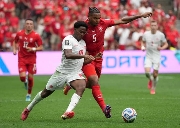 (260625) -- VANCOUVER, June 25, 2026 -- Jonathan David (L) of Canada vies with Manuel Akanji of Switzerland during the group B match between Switzerland and Canada at the 2026 FIFA World Cup, WM, Weltmeisterschaft, Fussball at BC Place Vancouver in Vancouver, Canada, June 24, 2026. ) (SP)CANADA-VANCOUVER-FOOTBALL-FIFA WORLD CUP-GROUP B-SUI VS CAN MengxYongmin 