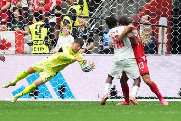 June 24, 2026, Vancouver, Bc, CANADA: Switzerland goalkeeper Gregor Kobel (1) makes a save as Canada s Jonathan David (10) battles with Ricardo Rodriguez (13) during the second half of a World Cup Group B soccer match, in Vancouver, on Wednesday, June 24, 2026. Canada News - June 24, 2026  - ZUMAc35_ 20260624_zaf_c35_230 Copyright: xEthanxCairnsx