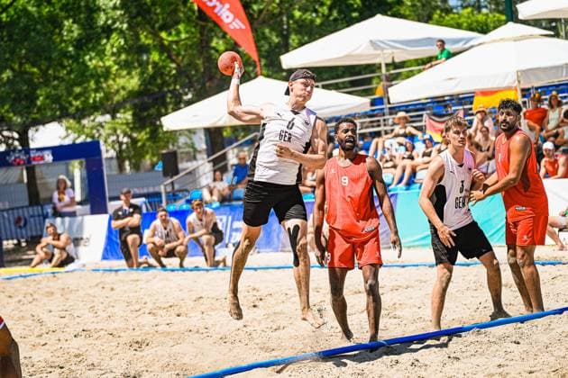 Lars Zelser ( 6; Deutschland Beachhandball Nationalmannschaft) springt hoch und holt zum Wurf aus, während Lennart Liebeck ( 3; Deutschland) und zwei Gegenspieler im Hintergrund die Szene beobachten. Das Spiel findet am Jarun See in Zagreb vor gut besetzten Zuschauerrängen statt. IHF Beach Handball World Championship, WM, Weltmeisterschaft 2026, 23.06.2026, Zagreb, Jarun See *** Lars Zelser 6 of Germany’s national beach handball team jumps high and winds up for a shot, while Lennart Liebeck 3 of Germany and two opposing players watch the scene in the background. The game takes place at Lake Jarun in Zagreb in front of a large crowd. 2026 IHF Beach Handball World Championship, June 23, 2026, Zagreb, Lake Jarun Copyright: xspeedshotx xDorianfrickx