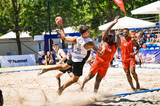 Tim Krauth ( 17; Deutschland Beachhandball Nationalmannschaft) springt im Sand und zieht ab, während ein Gegenspieler in rotem Trikot den Arm hochreißt, um den Wurf zu blocken. Im Hintergrund verfolgen Zuschauer die Szene am Jarun See in Zagreb. IHF Beach Handball World Championship, WM, Weltmeisterschaft 2026, 23.06.2026, Zagreb, Jarun See *** Tim Krauth, 17, of the German national beach handball team, jumps in the sand and takes a shot, while an opponent in a red jersey raises his arm to block the shot. In the background, spectators watch the action at Lake Jarun in Zagreb during the 2026 IHF Beach Handball World Championship, June 23, 2026, Zagreb, Lake Jarun Copyright: xspeedshotx xDorianfrickx