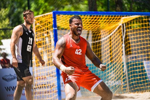 Ein Spieler in rotem Trikot mit der Nummer 42 jubelt mit geballten Fäusten lautstark vor dem gelb-blauen Beachhandball-Tor am Jarun See in Zagreb. Im Hintergrund ist Oliver Middell ( 20; Deutschland Beachhandball Nationalmannschaft) zu sehen. IHF Beach Handball World Championship, WM, Weltmeisterschaft 2026, 23.06.2026, Zagreb, Jarun See *** A player in a red jersey with the number 42 is celebrating loudly with his fists clenched in front of the yellow-and-blue beach handball goal at Lake Jarun in Zagreb. In the background is Oliver Middell of the German men’s beach handball national team. IHF Beach Handball World Championship 2026, June 23, 2026, Zagreb, Lake Jarun Copyright: xspeedshotx xDorianfrickx
