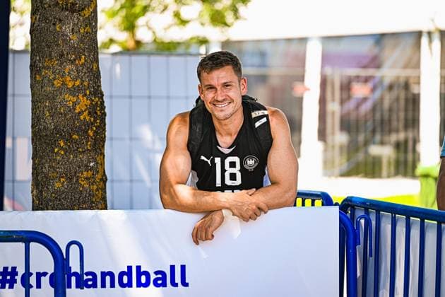Robin John ( 18; Deutschland Beachhandball Nationalmannschaft) lehnt lächelnd an einer Absperrung am Jarun See in Zagreb. Im Hintergrund ist das Banner mit dem Hashtag crohandball zu sehen. IHF Beach Handball World Championship, WM, Weltmeisterschaft 2026, 23.06.2026, Zagreb, Jarun See *** Robin John, 18, of the German national beach handball team, leans against a barrier at Lake Jarun in Zagreb, smiling. In the background is a banner with the hashtag crohandball. IHF Beach Handball World Championship 2026, June 23, 2026, Zagreb, Lake Jarun Copyright: xspeedshotx xDorianfrickx
