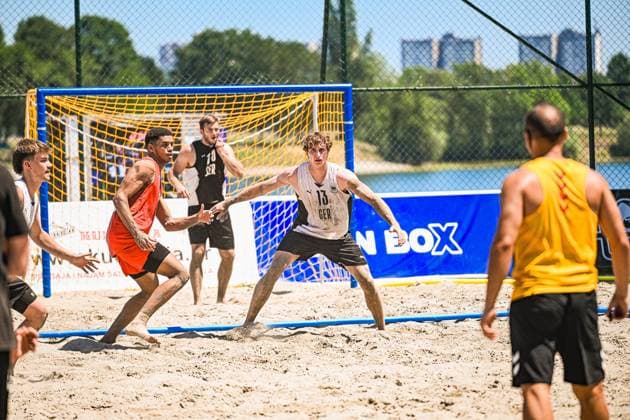 Severin Henrich ( 13; Deutschland Beachhandball Nationalmannschaft) steht tief in der Abwehr und deckt einen Angreifer im orangefarbenen Trikot vor dem Tor. Im Hintergrund ist ein weiterer deutscher Spieler zu sehen, während ein Gegenspieler in Gelb am rechten Bildrand die Szene beobachtet. IHF Beach Handball World Championship, WM, Weltmeisterschaft 2026, 23.06.2026, Zagreb, Jarun See *** Severin Henrich 13: The German national beach handball team is positioned deep in defense and marking an attacker in an orange jersey in front of the goal. Another German player can be seen in the background, while an opponent in yellow watches the scene from the right edge of the frame. 2026 IHF Beach Handball World Championship, June 23, 2026, Zagreb, Lake Jarun Copyright: xspeedshotx xDorianfrickx