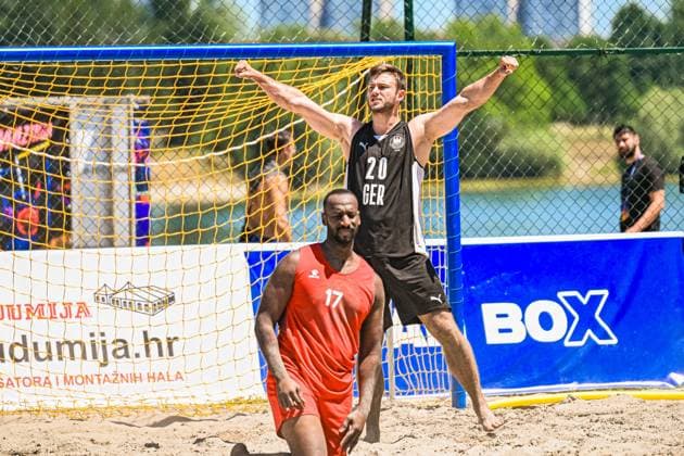 Oliver Middell ( 20; Deutschland Beachhandball Nationalmannschaft) reißt beide Arme in die Höhe und jubelt ausgelassen vor dem gelben Beachhandball-Tor. Im Vordergrund steht ein Gegenspieler im roten Trikot mit der Nummer 17, der enttäuscht wirkt. IHF Beach Handball World Championship, WM, Weltmeisterschaft 2026, 23.06.2026, Zagreb, Jarun See *** Oliver Middell 20: A member of the German national beach handball team raises both arms in the air and celebrates exuberantly in front of the yellow beach handball goal. In the foreground stands an opponent in a red jersey with the number 17, who looks disappointed. IHF Beach Handball World Championship 2026, June 23, 2026, Zagreb, Lake Jarun Copyright: xspeedshotx xDorianfrickx