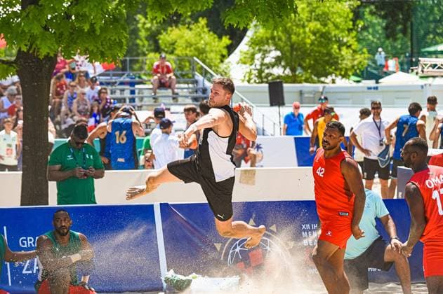 Ein Spieler der deutschen Beachhandball-Nationalmannschaft springt dynamisch zum Wurf und wirbelt Sand auf, während Gegenspieler in roten Trikots zusehen. Die Szene findet beim IHF Beach Handball World Championship, WM, Weltmeisterschaft am Jarun See in Zagreb statt. IHF Beach Handball World Championship 2026, 23.06.2026, Zagreb, Jarun See *** A player on the German national beach handball team leaps dynamically to take a shot, kicking up sand, while opponents in red jerseys look on. The scene takes place at the IHF Beach Handball World Championship at Lake Jarun in Zagreb. IHF Beach Handball World Championship 2026, June 23, 2026, Zagreb, Lake Jarun Copyright: xspeedshotx xDorianfrickx