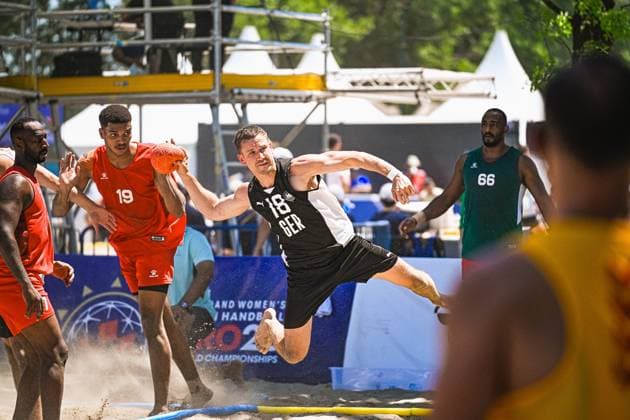 Robin John ( 18; Deutschland Beachhandball Nationalmannschaft) springt dynamisch zum Wurf und wirbelt Sand auf dem Beachhandball-Court am Jarun See in Zagreb auf. Im Hintergrund sind Gegenspieler in roten Trikots sowie ein Spieler mit Nummer 66 in grünem Trikot zu sehen. IHF Beach Handball World Championship, WM, Weltmeisterschaft 2026, 23.06.2026, Zagreb, Jarun See *** Robin John 18, a member of the German national beach handball team, leaps dynamically to take a shot, kicking up sand on the beach handball court at Lake Jarun in Zagreb. In the background, opponents in red jerseys can be seen, as well as a player wearing number 66 in a green jersey. IHF Beach Handball World Championship 2026, June 23, 2026, Zagreb, Lake Jarun Copyright: xspeedshotx xDorianfrickx