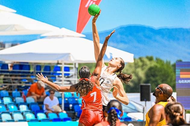 Eine Spielerin der Deutschen Frauen Beachhandball Nationalmannschaft springt hoch und hält den grünen Ball mit ausgestrecktem Arm über eine Gegenspielerin der USA ( 7) in rotem Trikot. Die Szene findet am Jarun See in Zagreb unter strahlend blauem Himmel statt. IHF Beach Handball World Championship, WM, Weltmeisterschaft 2026, 23.06.2026, Zagreb, Jarun See *** A player on the German women’s national beach handball team jumps high and holds the green ball with her arm outstretched over an opponent from Team USA 7, wearing a red jersey. The scene takes place at Lake Jarun in Zagreb under a bright blue sky. IHF Beach Handball World Championship 2026, June 23, 2026, Zagreb, Lake Jarun Copyright: xspeedshotx xDorianfrickx