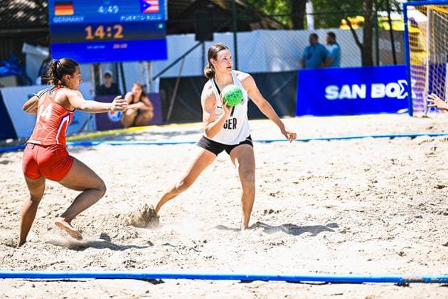 Eine Spielerin der Deutschen Frauen Beachhandball Nationalmannschaft hält den Ball und sucht die Anspielstation, während eine Gegenspielerin Puerto Ricos ( 14) den Druck erhöht. Die Anzeigetafel zeigt einen deutlichen Spielstand von 14:2 für Deutschland beim Turnier am Jarun See in Zagreb. IHF Beach Handball World Championship, WM, Weltmeisterschaft 2026, 23.06.2026, Zagreb, Jarun See *** A player on the German women s national beach handball team holds the ball and looks for a teammate to pass to, while an opposing player from Puerto Rico (No. 14) increases the pressure. The scoreboard shows a clear 14–2 lead for Germany at the tournament on Lake Jarun in Zagreb: 2026 IHF Beach Handball World Championship, June 23, 2026, Zagreb, Lake Jarun Copyright: xspeedshotx xDorianfrickx