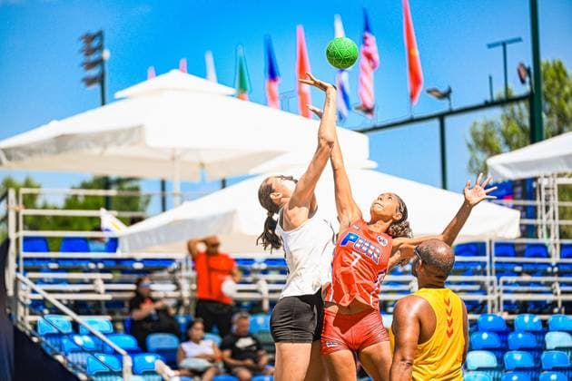 Zwei Spielerinnen springen hoch und kämpfen um den grünen Beachhandball, während im Hintergrund Länderflaggen im Wind wehen. Die Szene findet am Jarun See in Zagreb unter strahlendem Sonnenlicht statt. IHF Beach Handball World Championship, WM, Weltmeisterschaft 2026, 23.06.2026, Zagreb, Jarun See *** Two players jump high and battle for the green beach handball, while national flags flutter in the wind in the background. The scene takes place at Lake Jarun in Zagreb under bright sunshine. IHF Beach Handball World Championship 2026, June 23, 2026, Zagreb, Lake Jarun Copyright: xspeedshotx xDorianfrickx