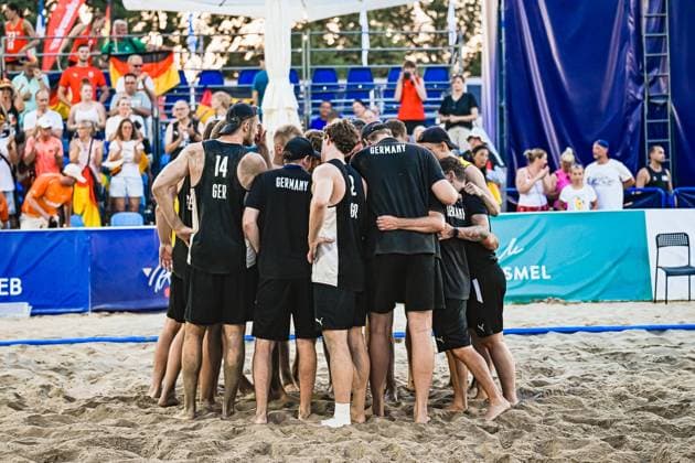 Die deutsche Beachhandball-Nationalmannschaft der Männer steht im Sand zu einem Teamkreis zusammen, darunter Hendrik Prahst ( 14; Deutschland Beachhandball Nationalmanschaft). Im Hintergrund verfolgen zahlreiche Zuschauer mit deutschen Fahnen die Szene am Jarun See in Zagreb. IHF Beach Handball World Championship, WM, Weltmeisterschaft 2026, 23.06.2026, Zagreb, Jarun See *** The German men s national beach handball team stands in a circle on the sand, including Hendrik Prahst (No. 14) of the German national beach handball team. In the background, numerous spectators waving German flags watch the scene at Lake Jarun in Zagreb during the 2026 IHF Beach Handball World Championship, June 23, 2026, Zagreb, Lake Jarun Copyright: xspeedshotx xDorianfrickx