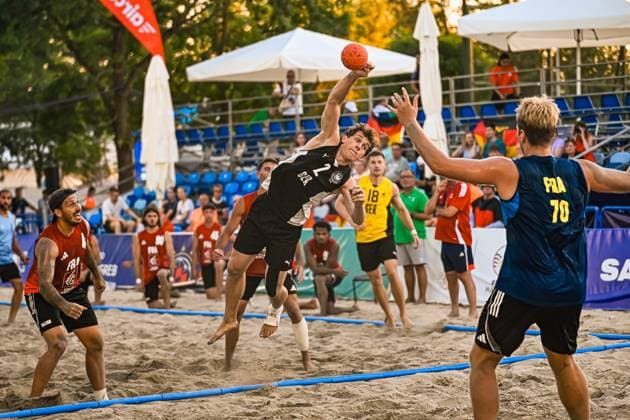 Lennart Wörmann ( 2; Deutschland Beachhandball Nationalmannschaft) springt hoch und zieht zum Wurf ab, während ein französischer Verteidiger ( 70; FRA) den Arm entgegenstreckt. Im Sand des Jarun Sees in Zagreb verfolgen zahlreiche Zuschauer die Szene. IHF Beach Handball World Championship, WM, Weltmeisterschaft 2026, 23.06.2026, Zagreb, Jarun See *** Lennart Wörmann 2 of the German national beach handball team jumps high and takes a shot, while a French defender 70 FRA reaches out his arm to block him. On the sand of Lake Jarun in Zagreb, numerous spectators watch the scene at the 2026 IHF Beach Handball World Championship, June 23, 2026, Zagreb, Lake Jarun Copyright: xspeedshotx xDorianfrickx