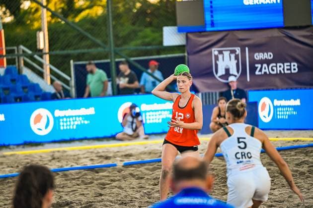 Dilayla Alarslan ( 12; Deutsche Frauen Beachhandball Nationalmannschaft) hält den Ball zum Wurf bereit und visiert das Tor an. Im Vordergrund ist eine Gegenspielerin mit der Nummer 5 auf dem CRO-Trikot zu sehen. IHF Beach Handball World Championship, WM, Weltmeisterschaft 2026, 23.06.2026, Zagreb, Jarun See *** Dilayla Alarslan 12, a member of the German women s national beach handball team, holds the ball ready to shoot and aims at the goal. In the foreground is an opposing player wearing a CRO jersey with the number 5. IHF Beach Handball World Championship 2026, June 23, 2026, Zagreb, Lake Jarun Copyright: xspeedshotx xDorianfrickx