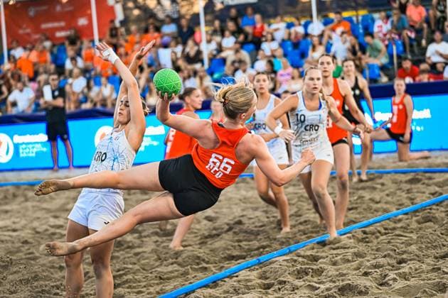 Amelie Möllmann ( 66; Deutsche Frauen Beachhandball Nationalmannschaft) zieht im Sprung ab und wird von einer kroatischen Gegenspielerin geblockt. Im Hintergrund verfolgen weitere Spielerinnen beider Teams die Aktion am Jarun See in Zagreb. IHF Beach Handball World Championship, WM, Weltmeisterschaft 2026, 23.06.2026, Zagreb, Jarun See *** Amelie Möllmann, 66, of the German women’s national beach handball team, jumps to shoot and is blocked by a Croatian opponent. In the background, other players from both teams watch the action at Lake Jarun in Zagreb during the 2026 IHF Beach Handball World Championship, June 23, 2026, Zagreb, Lake Jarun Copyright: xspeedshotx xDorianfrickx