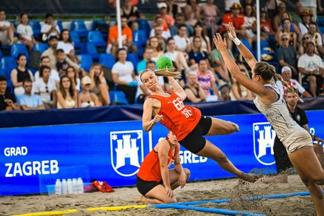 Amelie Möllmann ( 66; Deutsche Frauen Beachhandball Nationalmannschaft) springt im Sand und wirft den grünen Ball trotz Abwehrversuch einer Gegenspielerin. Im Hintergrund verfolgen zahlreiche Zuschauer die Szene am Jarun See in Zagreb. IHF Beach Handball World Championship, WM, Weltmeisterschaft 2026, 23.06.2026, Zagreb, Jarun See *** Amelie Möllmann, 66, of the German women’s national beach handball team, jumps in the sand and throws the green ball despite an opponent’s attempt to block her. In the background, numerous spectators watch the action at Lake Jarun in Zagreb during the 2026 IHF Beach Handball World Championship, June 23, 2026, Zagreb, Lake Jarun Copyright: xspeedshotx xDorianfrickx