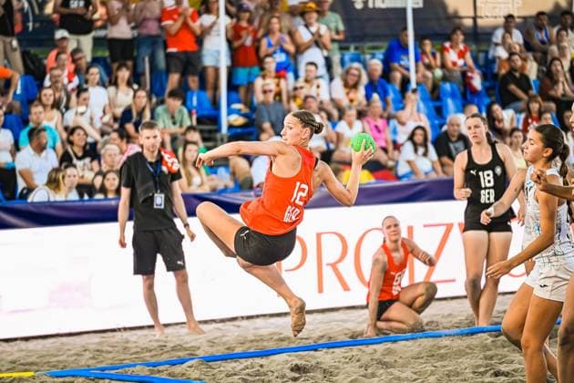 Eine Spielerin Georgiens springt dynamisch ab und holt zum Wurf aus, während Pauline Borrmann ( 18; Deutsche Frauen Beachhandball Nationalmannschaft) im Hintergrund die Szene beobachtet. Das Spiel findet am Jarun See in Zagreb vor voll besetzten Tribünen statt. IHF Beach Handball World Championship, WM, Weltmeisterschaft 2026, 23.06.2026, Zagreb, Jarun See *** A Georgian player takes off with a dynamic leap and winds up for a shot, while Pauline Borrmann of the German women’s beach handball national team watches the action in the background. The game is taking place at Lake Jarun in Zagreb in front of packed stands during the 2026 IHF Beach Handball World Championship, June 23, 2026, Zagreb, Lake Jarun Copyright: xspeedshotx xDorianfrickx