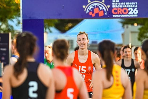 Julia Drachsler ( 15; Deutsche Frauen Beachhandball Nationalmannschaft) steht im roten Torwarttrikot unter dem Eingangstor der IHF Beach Handball World Championships CRO26 am Jarun See in Zagreb. Im Vordergrund sind Spielerinnen verschiedener Nationen von hinten zu sehen. IHF Beach Handball World Championship, WM, Weltmeisterschaft 2026, 23.06.2026, Zagreb, Jarun See *** Julia Drachsler, a member of the German women’s beach handball national team, stands in her red goalkeeper jersey beneath the entrance gate to the IHF Beach Handball World Championships CRO26 at Lake Jarun in Zagreb. In the foreground, players from various nations can be seen from behind. IHF Beach Handball World Championship 2026, June 23, 2026, Zagreb, Lake Jarun Copyright: xspeedshotx xDorianfrickx