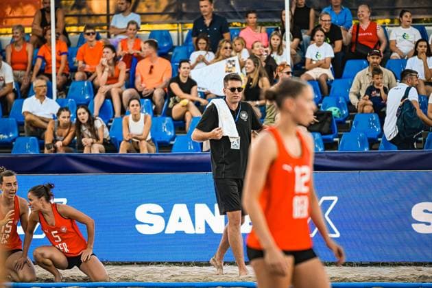Ein Betreuer der deutschen Frauen-Beachhandball-Nationalmannschaft beobachtet das Spielgeschehen am Spielfeldrand, während Kirsten Sophie Walter ( 5; Deutsche Frauen Beachhandball Nationalmanschaft) und eine Mitspielerin auf dem Sand agieren. Im Vordergrund läuft Dilayla Alarslan ( 12; Deutsche Frauen Beachhandball Nationalmanschaft) ins Bild, im Hintergrund verfolgen zahlreiche Zuschauer das Spiel. IHF Beach Handball World Championship, WM, Weltmeisterschaft 2026, 23.06.2026, Zagreb, Jarun See *** A coach for the German women’s national beach handball team watches the action from the sidelines, while Kirsten Sophie Walter (No. 5, German women’s national beach handball team) and a teammate play on the sand. In the foreground, Dilayla Alarslan (No. 12, German women’s national beach handball team) runs into the frame, while in the background, numerous spectators watch the game. IHF Beach Handball World Championship 2026, June 23, 2026, Zagreb, Lake Jarun Copyright: xspeedshotx xDorianfrickx
