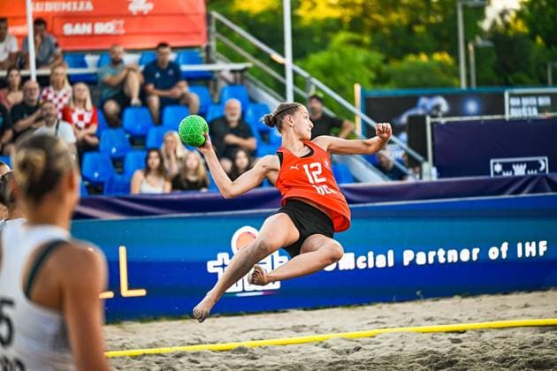 Mira Chew ( 12; USA woman) springt dynamisch ab und holt zum Wurf aus, der grüne Beachhandball klar in der erhobenen Hand. Im Vordergrund ist eine Gegenspielerin angeschnitten, im Hintergrund verfolgen Zuschauer das Spiel am Jarun See. IHF Beach Handball World Championship, WM, Weltmeisterschaft 2026, 23.06.2026, Zagreb, Jarun See *** Mira Chew, a 12-year-old girl from the U.S., takes off dynamically and winds up for a throw, the green beach handball clearly visible in her raised hand. In the foreground, an opposing player is shown in a close-up; in the background, spectators watch the game at Lake Jarun during the 2026 IHF Beach Handball World Championship, June 23, 2026, Zagreb, Lake Jarun Copyright: xspeedshotx xDorianfrickx