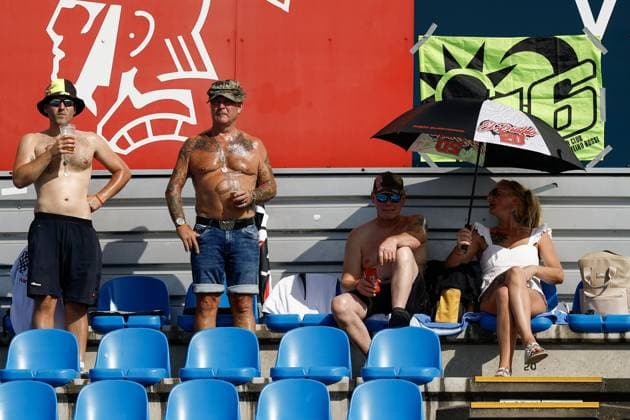 ASSEN - Atmospheric image of spectators in the stands seeking relief from the heat under a portable parasol during the Moto GP practice ahead of the 95th edition of the TT of Assen. VINCENT JANNINK ANP xVIxANPxSportx xxANPxIVx 562046112 originalFilename: 562046112.jpg