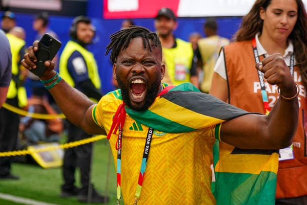 USA: Fußball FIFA World Cup, WM, Weltmeisterschaft, Fussball 2026, Sechzehntelfinale, Round of 32, Südafrika vs Kanada, South Africa vs Canada, SoFi Stadium (Inglewood, Los Angeles County, Kalifornien): Begeisterter Fußballfan aus Südafrika jubelt mit Nationalflagge über den Schultern und erhobenen Fäusten in die Kamera. Emotion, Fankultur, Porträt, Fanporträt, Südafrika, Nationaltrikot, Nationalflagge, Jubel, Leidenschaft, Stadion, FIFA World Cup 2026, WM 2026, Fußball, Smartphone, Akkreditierung, Volunteers, Sicherheitskräfte, Spieltag, Atmosphäre, Sportevent. *** USA Soccer FIFA World Cup 2026, Round of 32, South Africa vs. Canada, SoFi Stadium, Inglewood, Los Angeles County, California; An enthusiastic soccer fan from South Africa cheers for the camera with the national flag draped over his shoulders and his fists raised; Emotion, fan culture, portrait, fan portrait, South Africa, national jersey, national flag, celebration, passion, stadium, 2026 FIFA World Cup, 2026 World Cup, soccer, smartphone, accreditation, volunteers, security personnel, match day, atmosphere, sporting event Copyright: xJOERANxSTEINSIEKx
