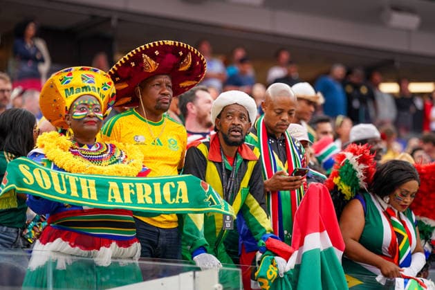 USA: Fußball FIFA World Cup, WM, Weltmeisterschaft, Fussball 2026, Sechzehntelfinale, Round of 32, Südafrika vs Kanada, South Africa vs Canada, SoFi Stadium (Inglewood, Los Angeles County, Kalifornien): Südafrikanische Fußballfans, Fanblock, Fankultur, Nationalfarben, Südafrika, Nationalflagge, Fanikone, Botha Msila, Mama Joy, traditionelle Kopfbedeckung, Gesichtsbemalung, Fanbekleidung, Schal, Fahne, Emotionen, Jubel, Begeisterung, Zuschauer, Tribüne, Gruppenporträt, Porträt, WM-Atmosphäre, Fußballbegeisterung, Support, Public, Fanaccessoires. *** USA Soccer FIFA World Cup 2026, Round of 32, South Africa vs. Canada, SoFi Stadium, Inglewood, Los Angeles County, California; South African soccer fans, fan section, fan culture, national colors, South Africa, national flag, fan icon, Botha Msila, Mama Joy, traditional headwear, face paint, fan apparel, scarf, flag, emotions, cheering, enthusiasm, spectators, stands, group portrait, portrait, World Cup atmosphere, soccer enthusiasm, support, public, fan accessories Copyright: xJOERANxSTEINSIEKx