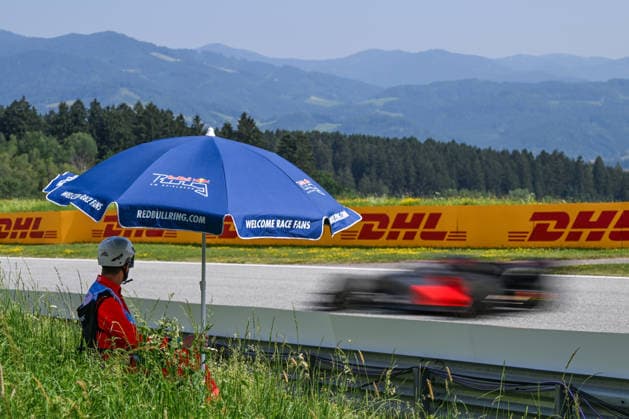 F1 Grand Prix Of Austria SPIELBERG, AUSTRIA - JUNE 28: A track marshal sits beneath a blue Red Bull Ring umbrella as a car passes in a motion blur during the F1 Grand Prix of Austria at Red Bull Ring on June 28, 2026 in Spielberg, Austria. Spielberg Austria  Copyright: xArturxWidakx originalFilename:widak-f1grandp260628_npx1U.jpg