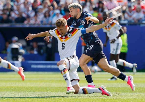 Germany s Joshua Kimmich (6) is tackled by Paraguay s Julio Enciso in the first half of a FIFA World Cup, WM, Weltmeisterschaft, Fussball match at Boston Stadium in Boston on Monday, June 29, 2026.  BOS20260629805 CJxGUNTHER