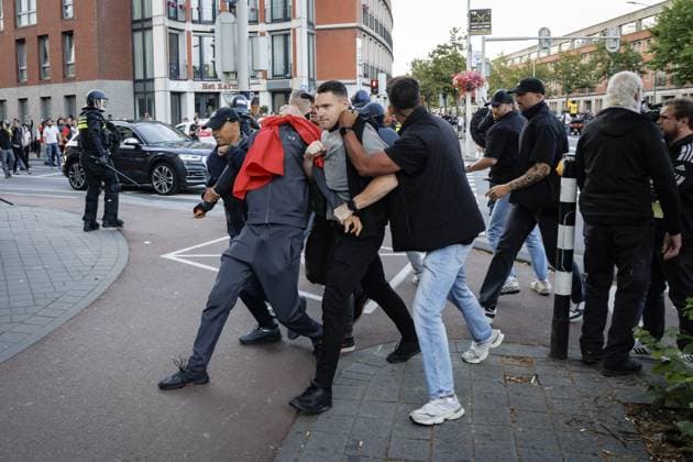 THE HAGUE - Police officers arrest a person while members of the Mobile Unit and a water cannon are deployed in the Schilderswijk district after the national team, Nationalteam won against the Netherlands at the World Cup. Moroccan supporters carried a Moroccan flag, honked horns, and set off fireworks. JOHN VAN DER TOL ANP xVIxANPxSportx xxANPxIVx 562424745 originalFilename: 562424745.jpg