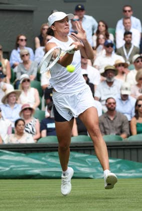Poland s Iga Swiatek plays a backhand in her match against American Taylor Townsend on day two of the 2026 Wimbledon Championships in London on Tuesday, June 30, 2026.  LON2026063064 HUGOxPHILPOTT