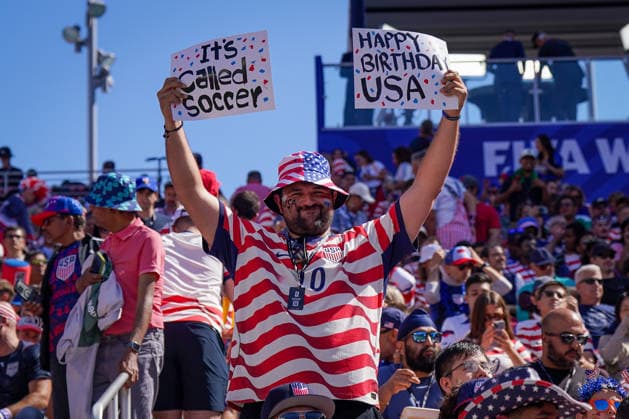 USA: Fußball FIFA World Cup, WM, Weltmeisterschaft, Fussball 2026, Sechzehntelfinale - USA vs Bosnien - Herzegowina im Levi™s Stadium (Santa Clara, San Francisco Bay Area, Kalifornien): US-Fußballfan hält vor dem Play-off-Spiel USA gegen Bosnien und Herzegowina zwei selbstgemalte Schilder mit den Aufschriften It™s Called Soccer und Happy Birthday USA in die Höhe. Fanporträt, Porträt, Tribüne, Zuschauer, USA-Trikot, US-Flagge, Fankultur, Transparent, Spruchband, Patriotismus, Nationalfeiertag, 4th of July, Stadionatmosphäre, Symbolbild. *** USA Soccer FIFA World Cup 2026, Round of 32: USA vs. Bosnia and Herzegovina at Levi’s Stadium in Santa Clara, San Francisco Bay Area, California. A U.S. soccer fan holds up two hand-painted signs reading It’s Called Soccer and Happy Birthday USA before the playoff match between the U.S. and Bosnia and Herzegovina. Fan portrait, portrait, stands, spectators, U.S. jersey, U.S. flag, fan culture, banner, slogan, patriotism, national holiday, 4th of July, stadium atmosphere, symbolic image Copyright: xJOERANxSTEINSIEKx