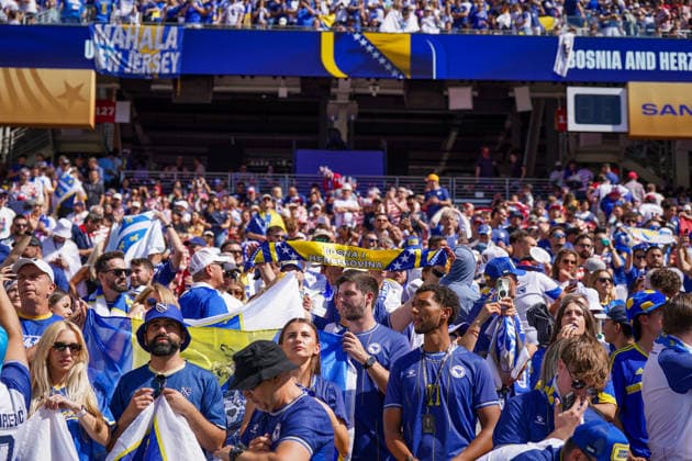 USA: Fußball FIFA World Cup, WM, Weltmeisterschaft, Fussball 2026, Sechzehntelfinale - USA vs Bosnien - Herzegowina im Levi™s Stadium (Santa Clara, San Francisco Bay Area, Kalifornien): Bosnien-Herzegowina-Fans auf der Tribüne des Levi™s Stadium vor dem Play-off-Spiel gegen die USA bei der FIFA Fußball-Weltmeisterschaft 2026. Zahlreiche Anhänger in Nationalfarben mit Fahnen, Schals und Fanbekleidung. Im Hintergrund Stadionanzeige mit Bosnia and Herzegovina. Zuschauer, Fans, Fankultur, Tribüne, Fahnen, Schals, Sportstätte, Innenansicht, Stimmung, Großereignis. *** USA Soccer FIFA World Cup 2026, Round of 32: USA vs. Bosnia and Herzegovina at Levi’s Stadium in Santa Clara, San Francisco Bay Area, California. Bosnia and Herzegovina fans in the stands at Levi’s Stadium before the playoff match against the U.S. at the 2026 FIFA World Cup. Numerous supporters dressed in national colors with flags, scarves, and fan apparel. In the background, the stadium scoreboard displays Bosnia and Herzegovina. Spectators, fans, fan culture, stands, flags, scarves, sports venue, interior view, atmosphere, major event Copyright: xJOERANxSTEINSIEKx